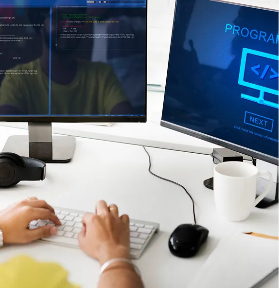 A developer working across two monitors of code