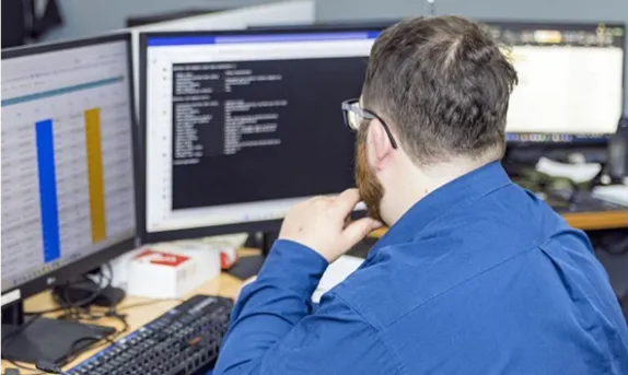 A DakTech engineer working at two monitors