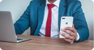 A businessman on a mobile phone at a laptop