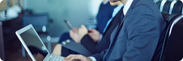 Business people working on laptops in a meeting