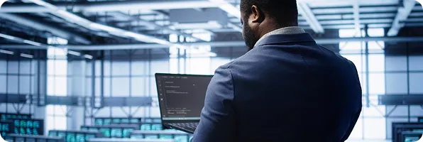 An engineer with a laptop in a server room
