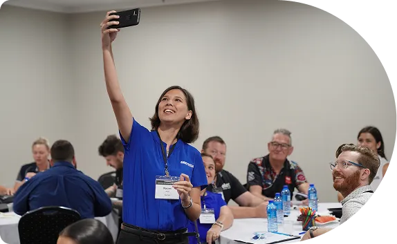 A DakTech team member taking a group selfie at a training session