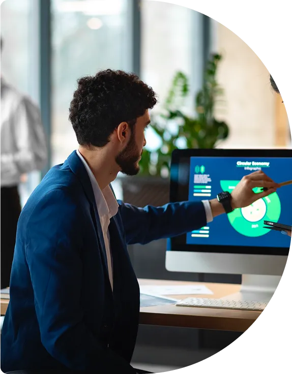A consultant pointing at a dashboard on a monitor